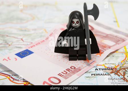 La mort de l'euro - la sinistre couche debout sur une note de 10 euros en haut d'une carte de l'Europe (Athènes, Grèce) Banque D'Images