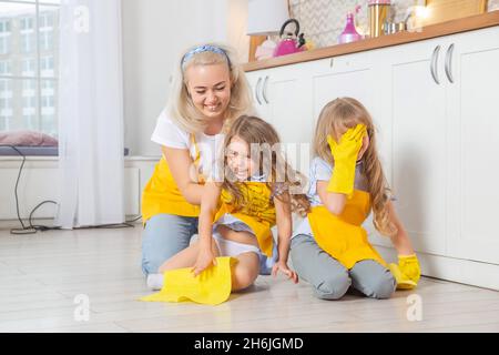 Souriant maman caucasienne enseignant filles humide de nettoyage de la cuisine.Deux générations de femmes ensemble dans la cuisine. Banque D'Images