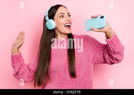 Photo d'une jolie femme mûre chantent dans le téléphone portez un pull rose isolé sur fond de couleur pastel Banque D'Images