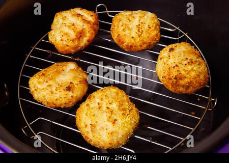 boulettes de poulet cuites sur la grille en acier de l'airfryer ouvert Banque D'Images