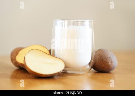 Photo de lait de pomme de terre sur fond en bois.Verre de lait de remplacement.Boisson végétarienne à base de plantes.Boisson sans lactose Banque D'Images