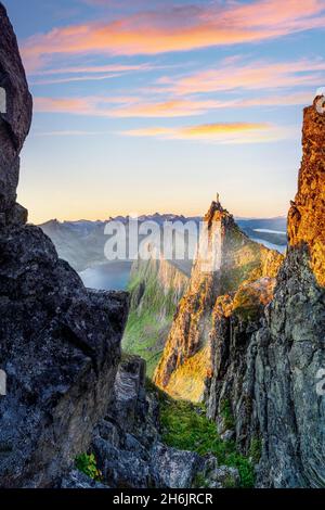 Randonneur admirant le lever du soleil se tenant au sommet de la montagne Husfjellet, Senja, comté de Troms, Norvège, Scandinavie,Europe Banque D'Images