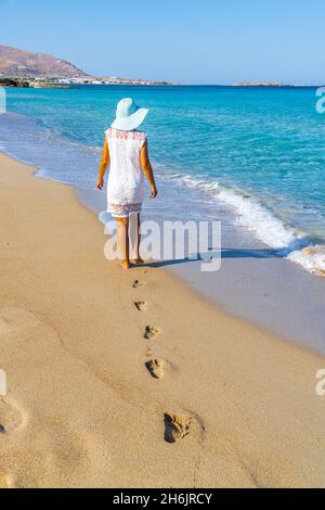 Jeune femme à la bals et au chapeau marchant sur une plage de sable, île de Crète, îles grecques, Grèce, Europe Banque D'Images