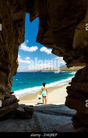 Vue arrière de la jeune femme admirant la mer de cristal de la grotte naturelle sur la plage de Triopetra, Plakias, Crète, Iles grecques, Grèce,Europe Banque D'Images