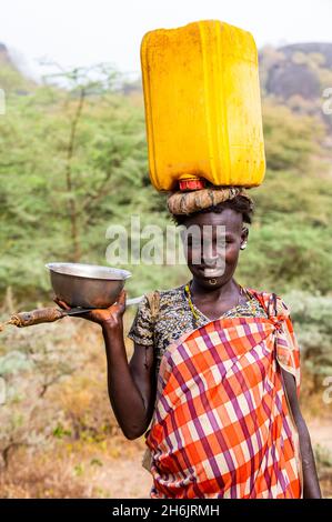 Femme avec un caniister d'eau sur sa tête, tribu Laarim, Boya Hills, Equatoria de l'est, Soudan du Sud, Afrique Banque D'Images