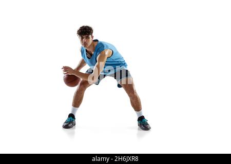 Portrait dynamique d'un joueur de basket-ball pratiquant isolé sur fond blanc de studio.Concepts de sport, de mouvement, d'activité, de mouvement. Banque D'Images