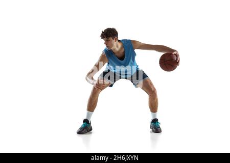 Portrait dynamique d'un joueur de basket-ball pratiquant isolé sur fond blanc de studio.Concepts de sport, de mouvement, d'activité, de mouvement. Banque D'Images