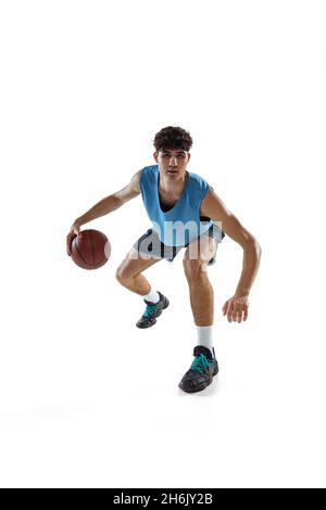 Portrait dynamique d'un joueur de basket-ball pratiquant isolé sur fond blanc de studio.Concepts de sport, de mouvement, d'activité, de mouvement. Banque D'Images