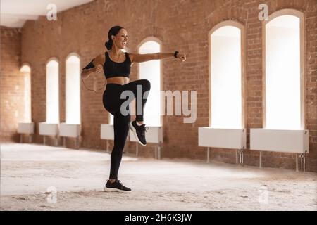 Entraînement actif.Athlétique Jeune femme dans Sportswear s'exercer dans un bâtiment urbain vide Banque D'Images