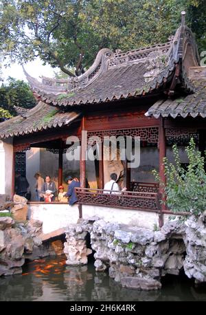 Jardins Yu Yuan, Shanghai, Chine: Les gens dans le jardin Yu regardant le poisson dans un petit étang.Yu Yuan est un jardin chinois traditionnel. Banque D'Images