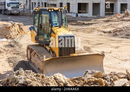 Un puissant bulldozer sur chenilles lourd travaille sur un chantier de construction Banque D'Images