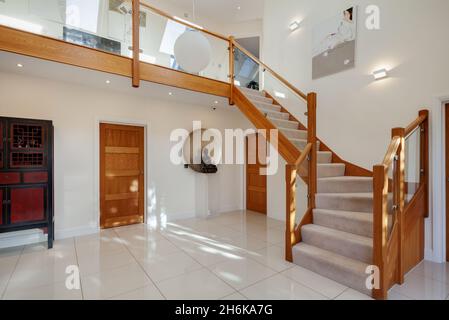 Essex, Angleterre - novembre 18 2019 : salle de réception dans une maison moderne contemporaine avec sol carrelé et escaliers en bois menant au premier étage. Banque D'Images