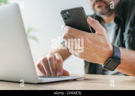 Indépendant utilisant un ordinateur portable et un smartphone mobile en même temps, le concept multitâche avec une focalisation sélective Banque D'Images