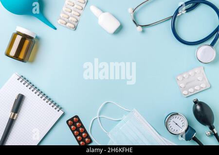 Concept médical, plat sur fond bleu.Copier l'espace au centre.Stéthoscope, tonometr, pilules et autres équipements médicaux sur une vue de dessus bleue Banque D'Images