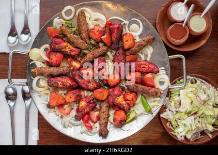 Sheffield Royaume-Uni – 11 mai 2018 : plat afghan partagé pour quatre avec légumes grillés épicés, kebab de sheesh et ailes de poulet tikka Banque D'Images