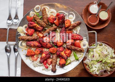 Sheffield Royaume-Uni – 11 mai 2018 : plat afghan partagé pour quatre avec légumes grillés épicés, kebab de sheesh et ailes de poulet tikka Banque D'Images