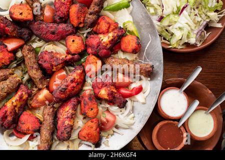 Sheffield Royaume-Uni – 11 mai 2018 : plat afghan partagé pour quatre avec légumes grillés épicés, kebab de sheesh et ailes de poulet tikka Banque D'Images