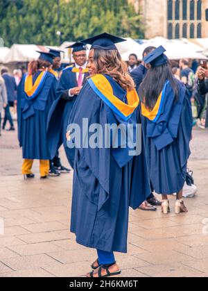 Les étudiants de l'université Anglia Ruskin dans leurs robes hautes en couleurs et mortarboards universitaires ont une casquette carrée pendant les célébrations de la remise des diplômes à Cambridge en Angleterre Banque D'Images