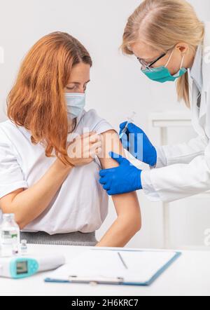 Médecin vaccinant le patient Banque D'Images