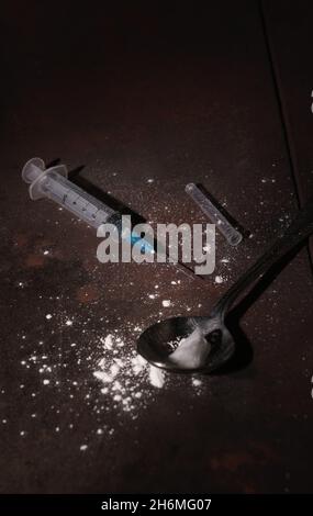 Seringue et cuillère sales sur le sol utilisées pour injecter des drogues avec de l'espace de copie Banque D'Images