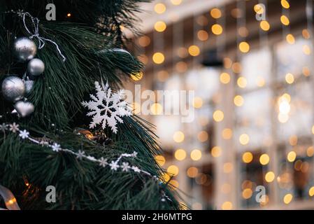 Sapin de Noël décoré sur un fond abstrait et étincelant avec espace copie.Guirlande de Noël avec étoiles et brindilles de pins sur fond de vacances Banque D'Images