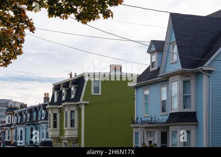 Une rue du centre-ville dans la journée à St. John's.Les maisons en rangée sont des bâtiments en bois colorés avec des toits de style mansarde et des dortoirs au-dessus des fenêtres. Banque D'Images