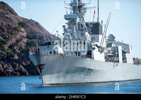 Le navire de guerre frégate de Halifax du HMSC naviguant dans le port de St. John's après un exercice militaire en mer.Il y a du terrain des deux côtés du navire Banque D'Images