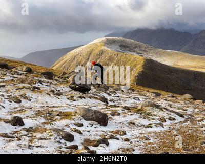 Un randonneur sur Beinn na Cailich, une colline derrière Broadford sur l'île de Skye, en Écosse, au Royaume-Uni, en regardant vers les montagnes Cuillin. Banque D'Images