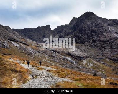 Des randonneurs qui marchent dans Coire Lagan sous Sgurr Mhic Choinnich; et Sgurr Alasdair sur la crête de Cuillin sur l'île de Skye, en Écosse, au Royaume-Uni, de Glen Britt Banque D'Images