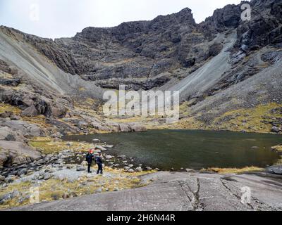 Coire Lagan en contrebas de Sgurr Mhic Choinich; et Sgurr Alasdair sur la crête de Cuillin sur l'île de Skye, en Écosse, au Royaume-Uni avec des alpinistes. Banque D'Images