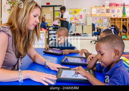 Une enseignante de pré-maternelle aide ses élèves à faire entendre des mots sur leurs iPad Apple, le 18 mai 2012, à Columbus, Mississippi. Banque D'Images