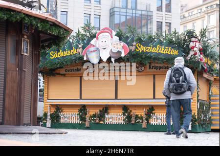 Dresde, Allemagne.16 novembre 2021.Les passants marchent devant les étals fermés du Striezelmarkt.L'Office de Tourisme de Dresde compte sur le traditionnel Striezelmarkt dans la capitale saxonne pour avoir lieu cette année malgré la pandémie de Corona.Credit: Sebastian Kahnert/dpa-Zentralbild/dpa/Alay Live News Banque D'Images