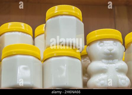 Miel naturel dans divers bocaux sur une étagère en bois, marché souvenir du village. Banque D'Images