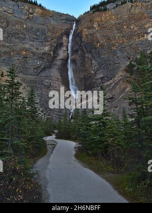 Belle vue sur la majestueuse cascade Takakkaw Falls dans le parc national Yoho, Colombie-Britannique, Canada dans les montagnes Rocheuses en soirée avec sentier. Banque D'Images