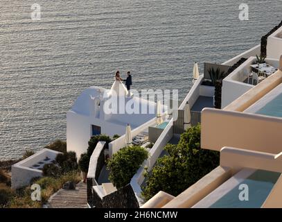 Imerovigli, Santorini, Grèce - 29 juin 2021 : la mariée et le marié lors d'une séance photo romantique à Imergovigli sur l'île de Santorini. Banque D'Images