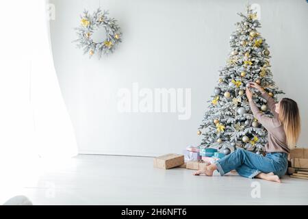 Belle femme décorent un arbre blanc de Noël nouvel an cadeaux décor Banque D'Images