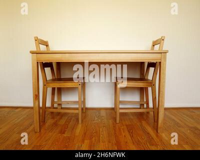 Décor intérieur simple avec deux chaises en bois et une table sur un plancher en bois Banque D'Images