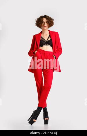 Portrait d'une femme en rouge pantsui et poteau chaussures de danse supports avec les mains dans les poches Banque D'Images