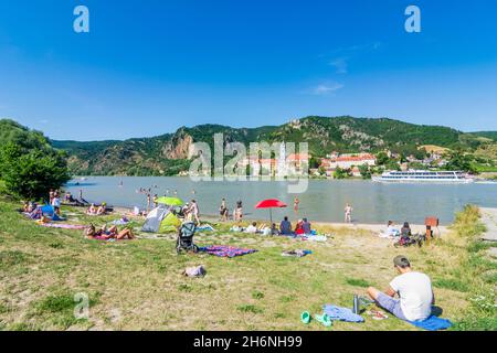 Dürnstein: Baigneurs à la plage au Donau (Danube) face au château de Dürnstein et à l'abbaye de Dürnstein (Stift Dürnstein), bateau, bateau, à Wachau, Niederöster Banque D'Images