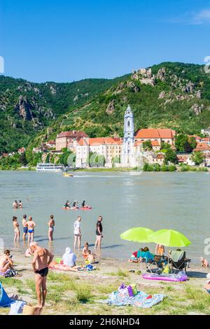 Dürnstein: Baigneurs à la plage au Donau (Danube) face au château de Dürnstein et à l'abbaye de Dürnstein (Stift Dürnstein), bateau, bateau, à Wachau, Niederöster Banque D'Images