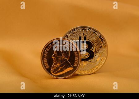 Pièce d'or physique 1 oz or Krugerrand contre Paul Kruger et pièce de bitcoin physique, image symbole or contre crypto-monnaie Banque D'Images