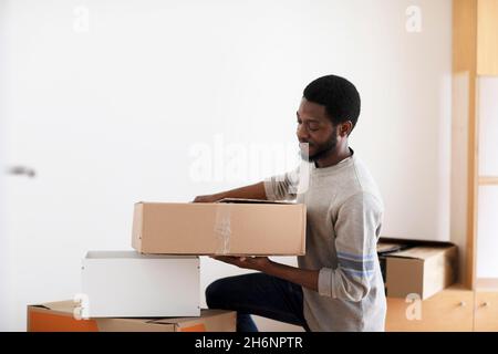 Jeune homme, étudiant, fait un déménagement à un autre plat Banque D'Images