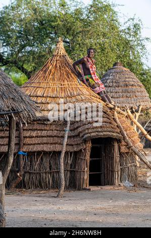 Femme réparant le toit d'une hutte traditionnelle de la tribu Toposa, Équatoria de l'est, Soudan du Sud Banque D'Images