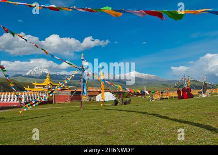 Toits d'or et chorten d'un monastère tibétain dans la prairie de Tagong en face du mont Zhara Lhatse, Yala Snow Mountain, 5820m, Lhakang Banque D'Images