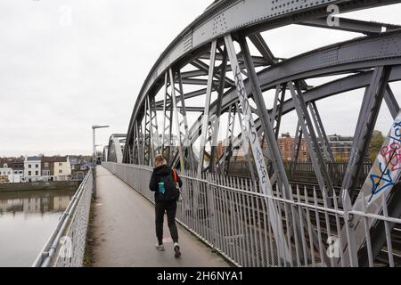 Une jeune femme marchant le long d'un pont de chemin de fer Barnes désert dans le sud-ouest de Londres, Angleterre, Royaume-Uni Banque D'Images