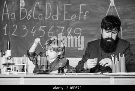 Jouez avec des liquides.Exemple personnel inspirant.Connaissances scolaires.Professeur et laboratoire de chimie de garçon.Journée de la connaissance vacances de septembre.Niveau de base Banque D'Images