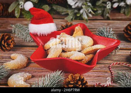 Les biscuits de noël Crescent appelés 'Vanillekipferl', des biscuits de Noël traditionnels autrichiens ou allemands avec des noix et du sucre glace dans un bol Banque D'Images