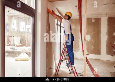 Papier peint de construction pour hommes suspendu au mur Banque D'Images