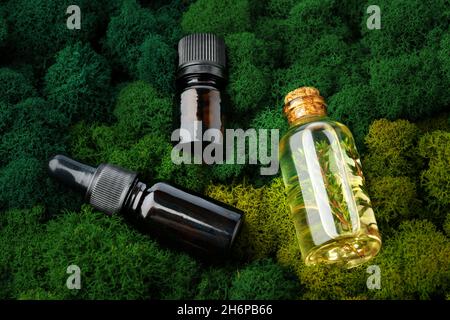 Ensemble de bouteilles de verre brun produits de beauté sur fond de mousse Banque D'Images