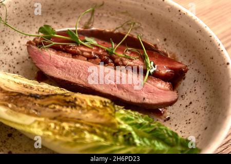 Mise au point douce.Entrecote boeuf steak grillé viande avec flammes de feu sur bois coupé avec branche de laitue, poivre et sel .Chef cuisinier maître cuisine de Banque D'Images